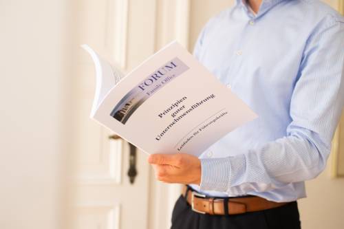 Een man in een blauw shirt bladert door een handboek.