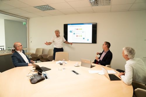 Eine Gruppe von vier Männern hat ein Review Meeting in einem Meeting Raum.